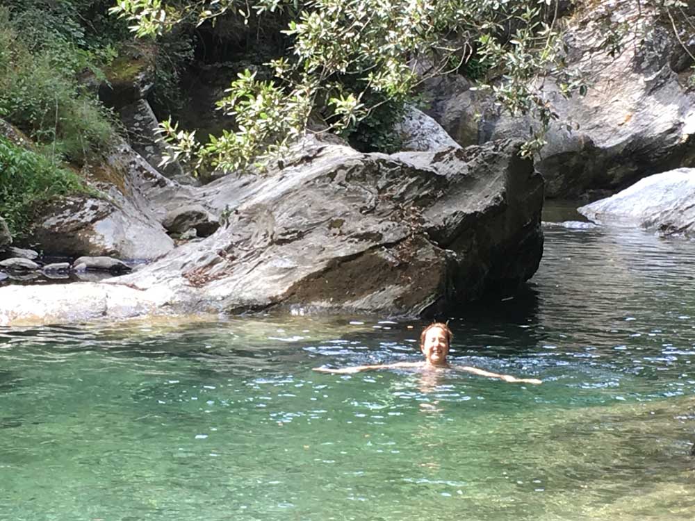 Swimming in river with rocks in background