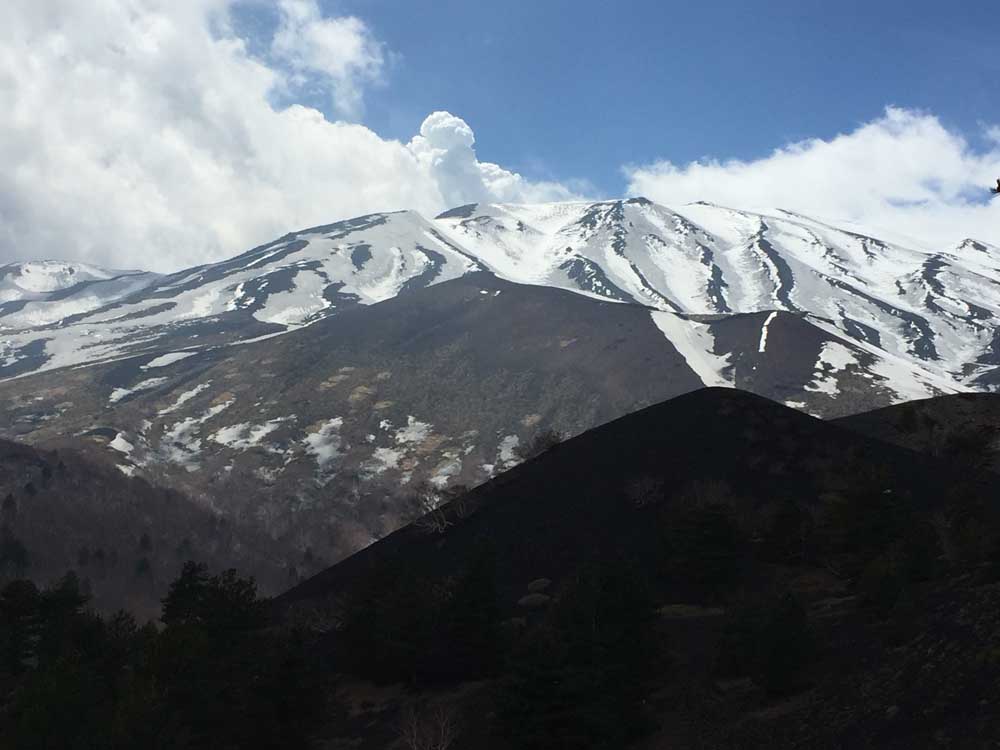 volcanic landscape with snowcapped peaks in the background, mount etna, sicily