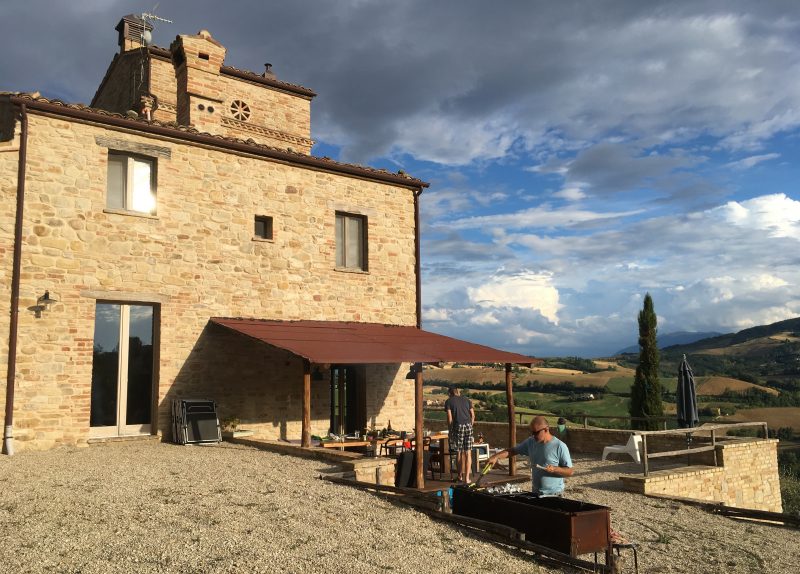 Man cooking outside villa in Italy