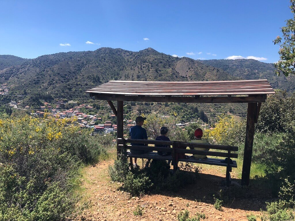 Family sitting on bench in mountains